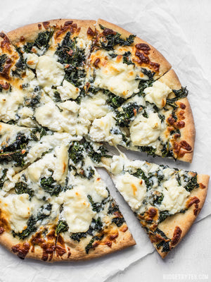 
                  
                    Load image into Gallery viewer, Garlicky Kale and Ricotta Pizza sliced, with one slice being pulled away
                  
                
